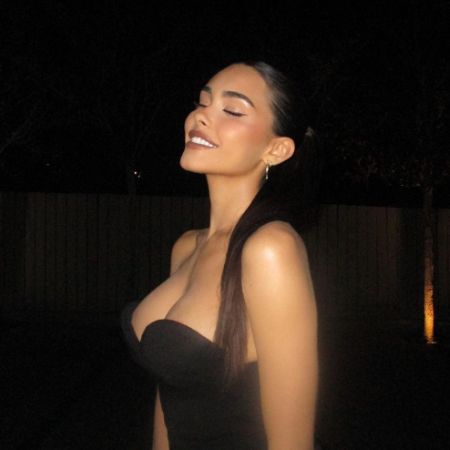 Madison Beer took a picture in a low-cut black dress.